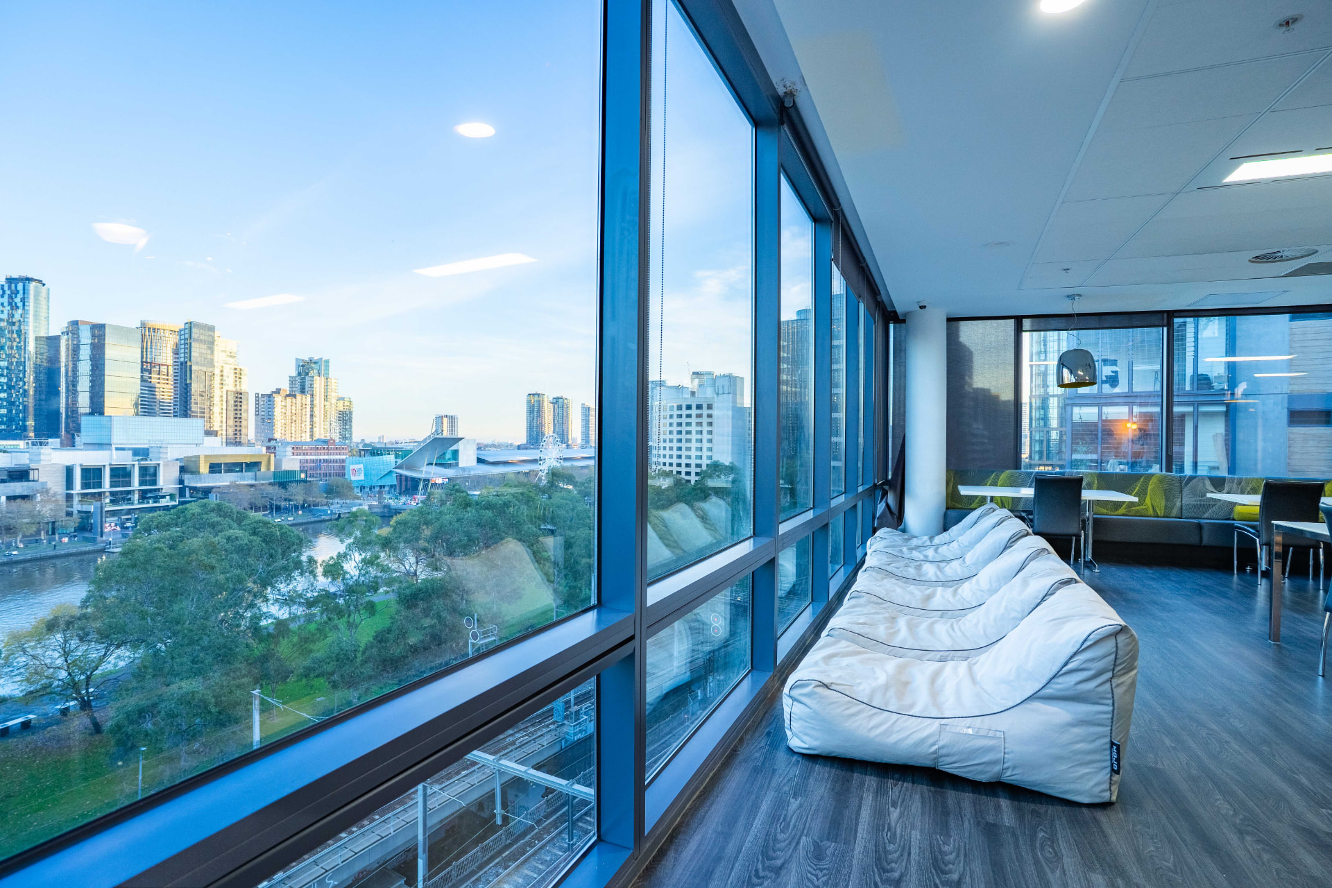Melbourne skyline and the Yarra River seen through the full-height windows of the Bayside campus lounge